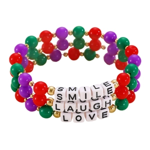 Close-up of beaded bracelets with Smile Laugh Love letter charms and colorful beads