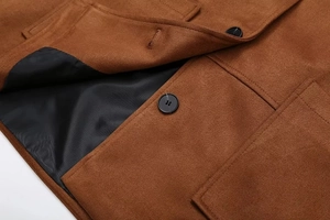Détail de la texture d'une veste en laine marron avec boutons noirs en résine