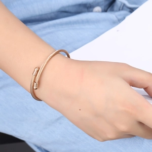 Rose gold stainless steel twisted cable wire open bangle bracelet worn on wrist
