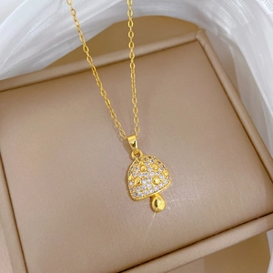 Macro shot of a gold mushroom pendant necklace with sparkling crystal zircon inlay