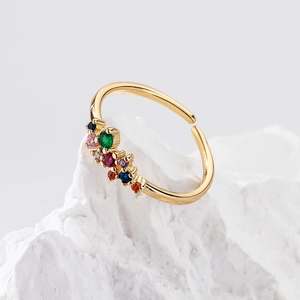 Adjustable gold plated flower ring with multi-colored zircons on white textured stone