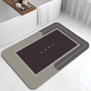 Detail view of a non-slip grey diatomaceous earth bath mat with HOME text in a modern bathroom