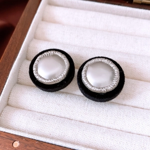 Detail of vintage round stud earrings with black velvet, pearl center and silver metal trim