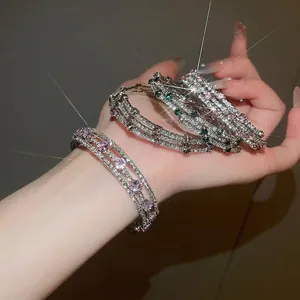 Three-layer wrap zircon bangle set in pink, emerald, and clear stones on a hand
