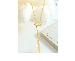 Detailed macro view of a 18k gold-plated OT buckle necklace with long pendant and ring