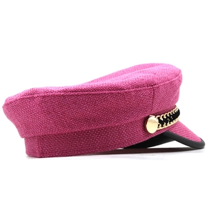 Detail of rose pink newsboy hat featuring textured tweed fabric and gold chain decor