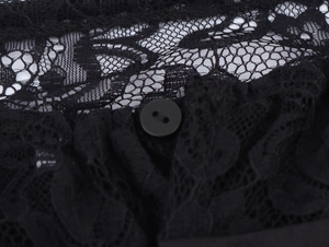 Detailed macro view of black lace fabric texture and a matte round button closure