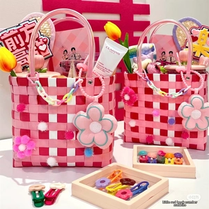 Detail of handmade woven gift basket with pink plush flowers and grooming accessories