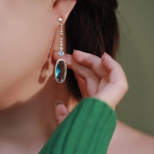 Elegant gold earrings with oval turquoise stone and sparkling cubic zirconia tassels