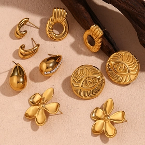 Flat lay of 18K gold plated geometric petal earrings and crystal drop studs