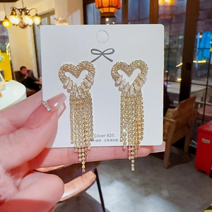 Detailed view of long heart-shaped tassel earrings with 925 silver needles and zircons