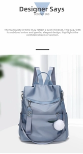 Detail view of water-resistant nylon backpack with stylish pompom charm and side pockets
