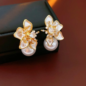 Macro detail of French vintage floral pearl earrings with gold plating and white petals