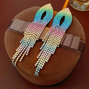 Close-up of vibrant gradient rhinestone tassel earrings on a brown ribbon gift box