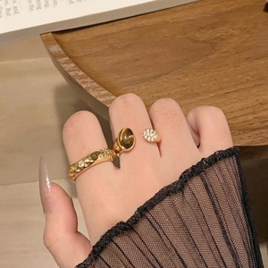 Dettaglio anello placcato oro con occhio di tigre, zirconi e fascia effetto lava