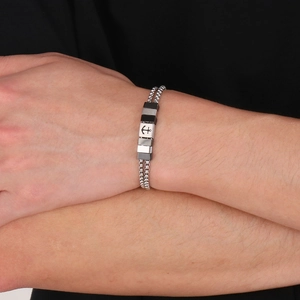 Detail of men's double-layer steel bracelet with anchor symbol on bicolour link