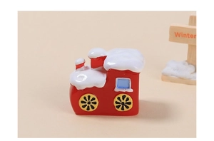 Macro view of a red Christmas train resin charm with white snow on the roof