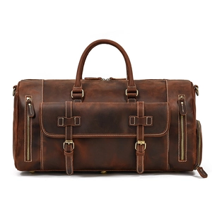 Front view of a dark brown leather travel bag featuring vintage buckles and zippers
