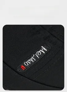 Detailed view of white H-MOI letter embroidery on a black twill flat top cap fabric