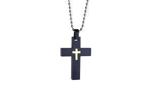 Detail of a black punk cross pendant with a gold inlay on a silver bead chain