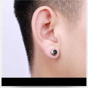 Macro detail of a minimalist black crystal stud earring in polished titanium steel.