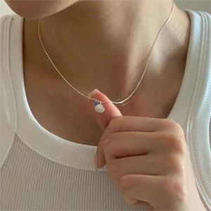 Elegant 925 sterling silver shell necklace with a blue zircon drop worn by a model