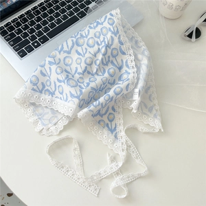 Detailed close-up of a floral cotton linen head scarf with delicate white lace trim