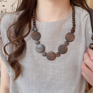 Detailed view of vintage ethnic wooden bead necklace with geometric circular pendant