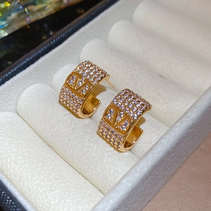 Macro shot of gold-plated silver earrings with pavé zircon and a V-shaped luxury design