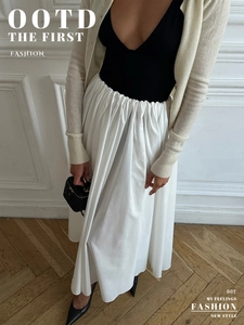 Detailed view of the elastic high waist and pleated texture of this long white maxi skirt