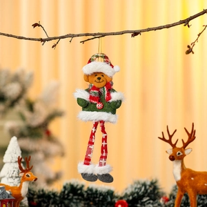 Close-up of plush Christmas bear ornament hanging on branch with festive decor