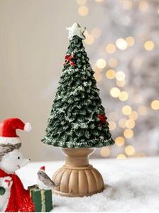 Detailed view of mini Christmas tree with red bows, silver star, and rustic wooden base