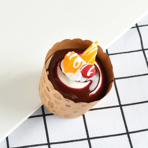 Realistic artificial cupcake model with chocolate sauce, cream, and orange fruit slices