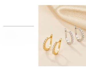 Detail of 925 sterling silver hoop earrings with sparkling cubic zirconia in gold and silver