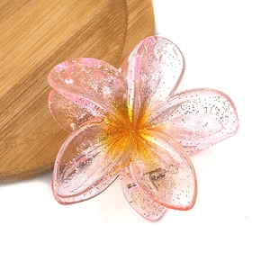 Detail of pink gradient frangipani hair claw clip with glitter and acrylic texture