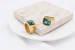 Macro detail of men's titanium steel rings with gold finish and inlaid abalone shell