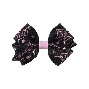 Detail of Halloween hair clip with black spider web and pink star ribbon patterns