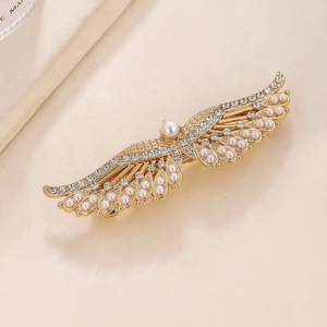 Elegant gold wing hair clip with rhinestones and white pearls on a minimalist background