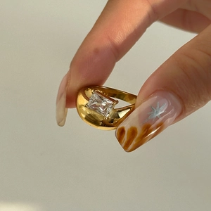 Macro detail of 18k gold plated curved ring with clear rectangular zircon stone