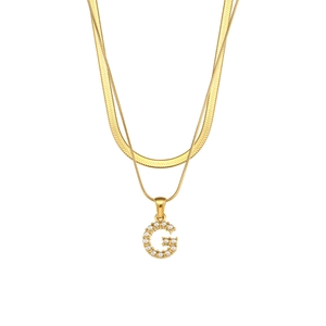 Detailed close-up of double-layer gold snake chain featuring a pearl-inlaid letter G pendant