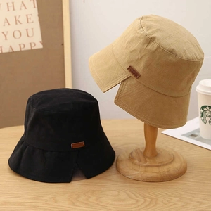 Detail view of cotton-linen sun hats in black and khaki with split brim and leather tag