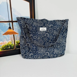 Close-up of navy blue paisley canvas bag with white logo label and durable fabric texture