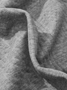 Macro shot of gray knitted fabric texture showing premium jacquard weave details