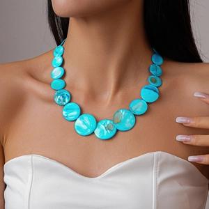 Detail of vibrant blue round shell beads on a statement necklace with unique textures