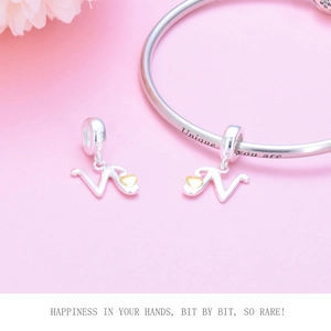 Macro view of S925 sterling silver letter W charm with small gold heart on snake chain