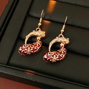 Close-up of vintage golden drop earrings with red enamel and sparkling rhinestones