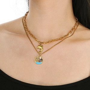 Détail du collier double rang en acier doré avec pendentifs dauphin et cocotier