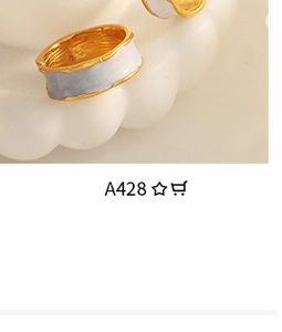 Detail of white enamel rings with irregular gold hammered texture on wave base