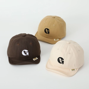 Detailed view of soft cotton baby caps with embroidered G letter in three neutral colors