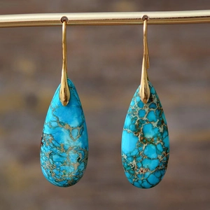 Detailed macro view of bohemian teardrop turquoise earrings with natural stone matrix